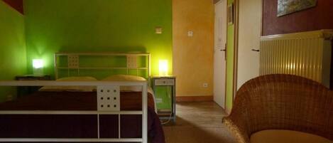Una habitación con literas, una silla, una mesita de noche y una lámpara.