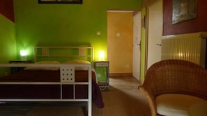 Huoneessa on kerrossänky, tuoli, yöpöytä ja lamppu.