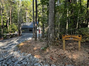 A forested area with a sign indicating 'The Bungalow at Valley Bear Farms, Bald Rock Rd.' - Cozy and Secluded Cottage in the Woods of Western North Carolina, near Pisgah National Forest (Balsam Grove)