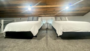 A room with two beds, a small table, and a window with blinds. - Creek Cabin ADA accessible in Livingston, Texas (Livingston)