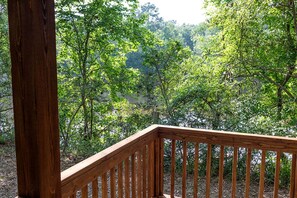 A wooden deck with a view of a forested area. - Creek Cabin ADA accessible in Livingston, Texas (Livingston)