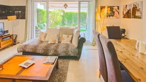 A living room with a sofa, a coffee table, a TV, and a dining area with chairs and a table. - Awesome home in Mijas with swimming pool (Mijas)