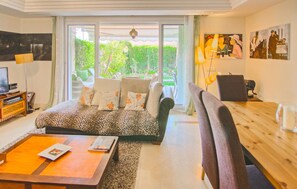A living room with a sofa, a coffee table, a TV, and a dining area with chairs and a table. - Awesome home in Mijas with swimming pool (Mijas)