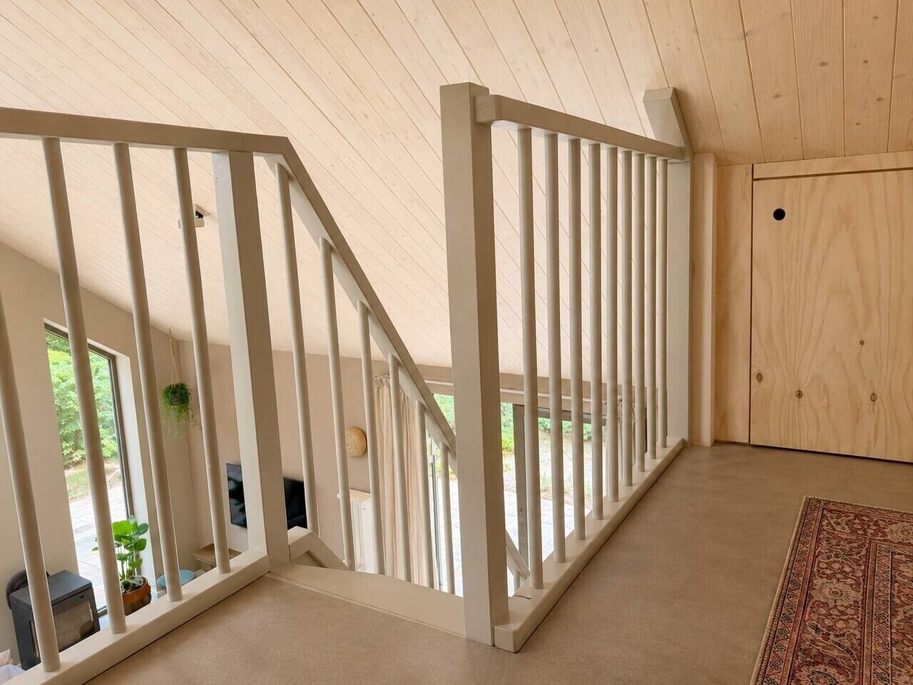 A wooden staircase with white railings leading to an outdoor area.