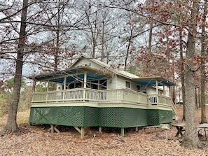 A two-story house with a balcony, surrounded by trees. - Inviting Lakefront Cabin with Boat Launch near Zwolle, Louisiana (Zwolle)