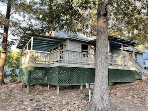 A two-story house with a balcony, a covered porch, and a tree in front. - Inviting Lakefront Cabin with Boat Launch near Zwolle, Louisiana (Zwolle)