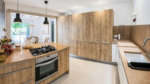 Una cocina moderna con armarios de madera, una estufa a gas y un lavamanos.