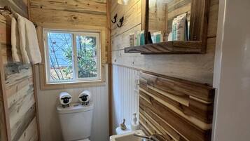 Ein kleines Badezimmer mit Toilette, Waschbecken und Fenster.