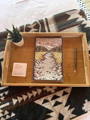 A wooden tray with a book, a pen, and a small potted plant. - Charming Standard Safari Tent with Fire Pit Near Jonathan Dickinson State Park in Hobe Sound, Florida (Hobe Sound)