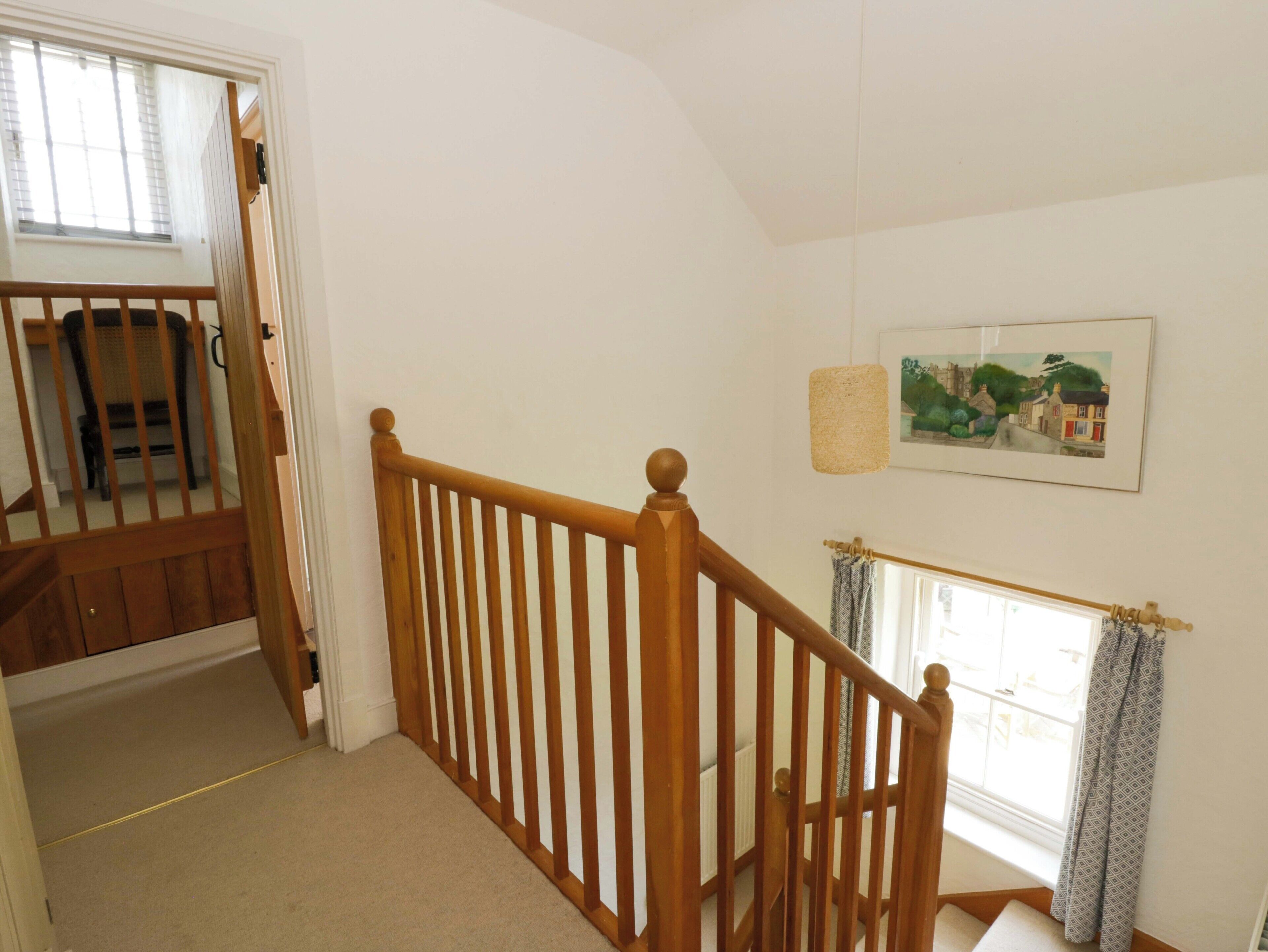 A staircase with wooden railings leading to a landing.