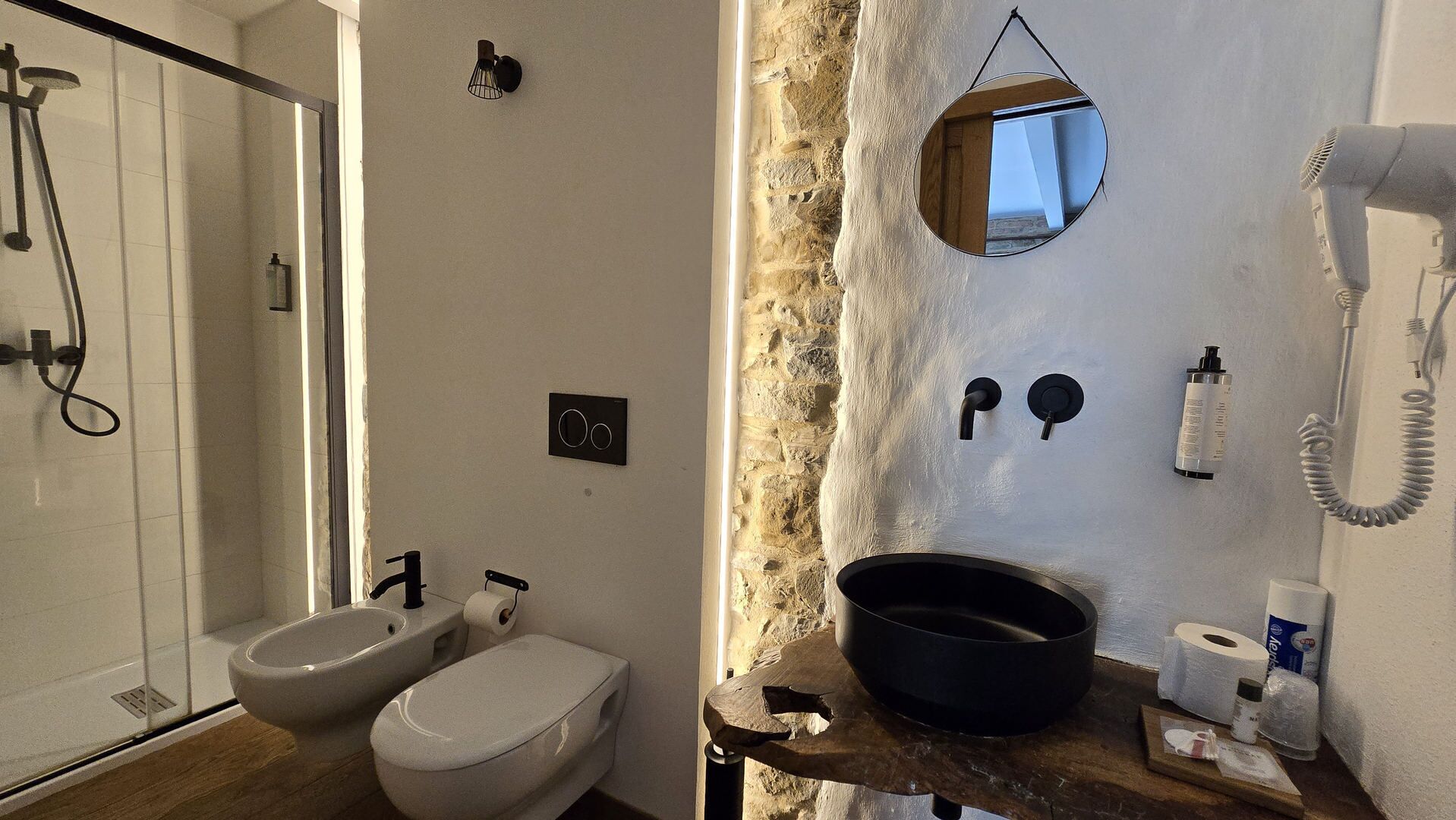 Un baño con ducha, bidé, inodoro y espejo.