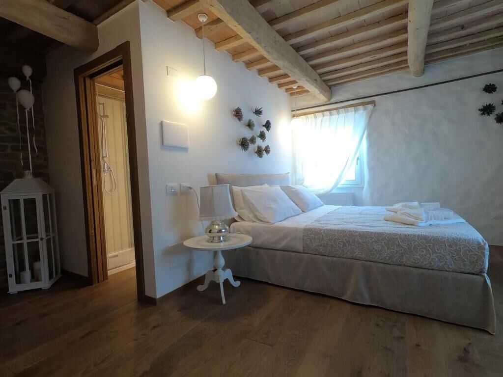 A bedroom with a bed, bedside table, lamp, and decorative wall plants.