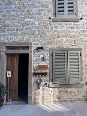 A stone building with a wooden door, shutters, and a sign reading 'Café Mie.' - Cà Maina (Santa Sofia)