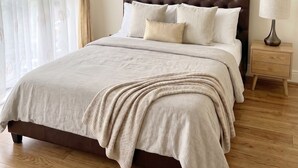 A bedroom with a bed, a nightstand, a lamp, and three framed artworks on the wall. - 2BR w/ Private Balcony & River Thames Views (London)