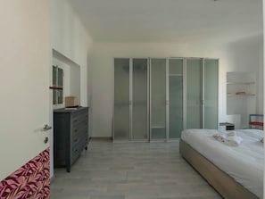 A bedroom with a bed, a dresser, a wardrobe, and a mirror. - HomeLovers Spacious Flat B.Aires District MM1 (Milano)
