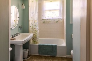 Ein Badezimmer mit Waschbecken, Spiegel und Badewanne.