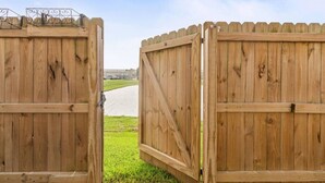 Dues portes de fusta obertes que donen a un camí empedrat.