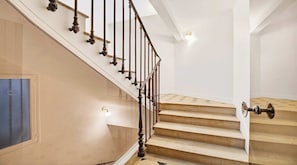 A staircase with a classic design, a glass door, and a light fixture on the wall. - Luxury Paris Penthouse with Panoramic Rooftop Views | Saint-Germain (Paris)