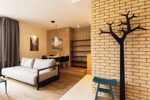 A modern living room with a sofa, a dining table, and a decorative wall piece. - Aapartments - Ideal City Center Location (Warszawa)