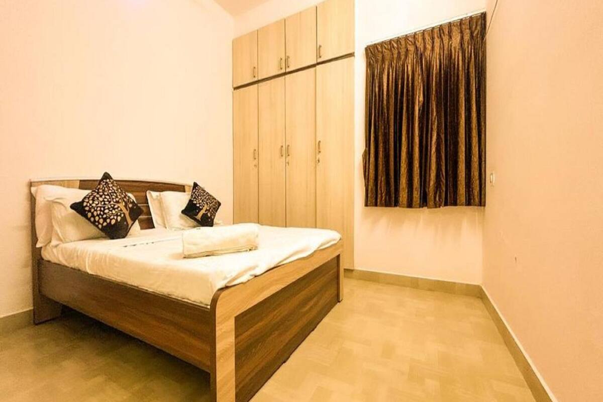 Ein Schlafzimmer mit einem hölzernen Bett, einem Kleiderschrank und einem Fenster mit Vorhängen.