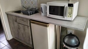 A compact kitchen with a microwave, sink, and dishwasher.
