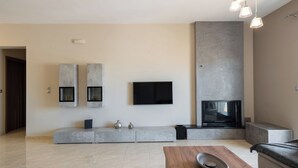 Ein modernes Wohnzimmer mit Flachbildfernseher, Einbauschränken, Kamin und einer Sitzecke.
