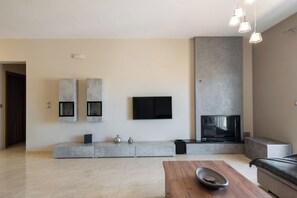 Ein modernes Wohnzimmer mit Flachbildfernseher, Einbauschränken, Kamin und einer Sitzecke.