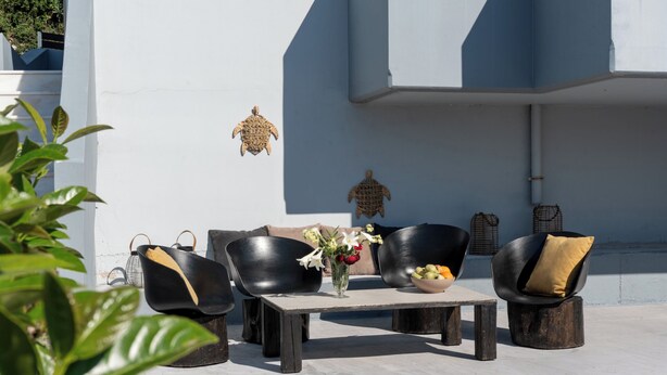 Ein Sitzbereich im Freien mit Tisch, St ühlen und einem Blumenstrauß.
