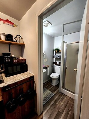 A compact bathroom with a toilet, sink, and shower area.