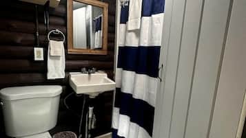 A bathroom with a toilet, sink, and shower curtain.
