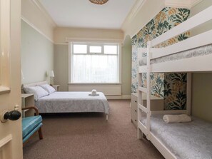 Ein Zimmer mit zwei Betten, einem Fenster und einer Heizung.