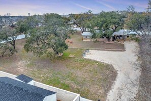 A residential area with a house, a small building, and a paved driveway.