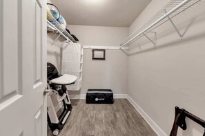 A compact storage closet with shelves, a small table, and a storage box.