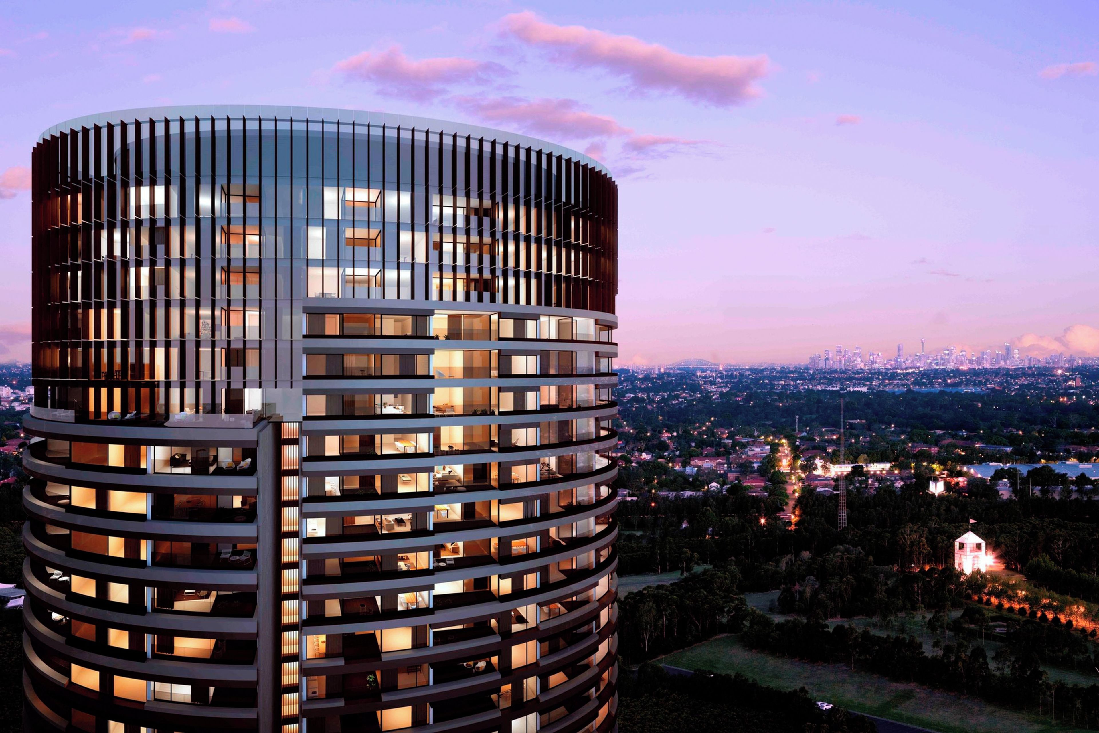 A modern high-rise building with a cylindrical glass facade and multiple balconies.