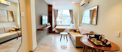 A modern living room with a sofa, a dining table, and a TV.