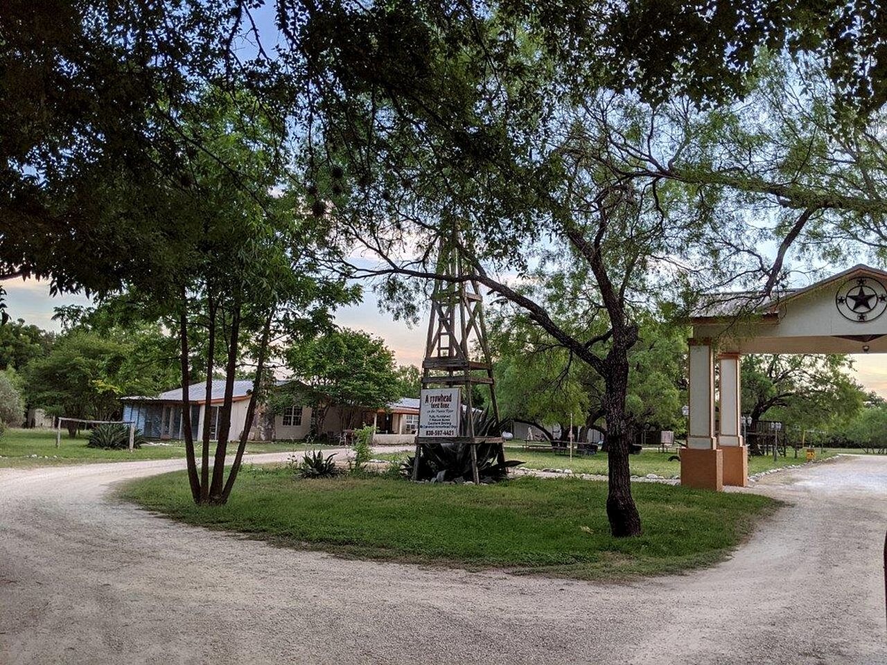 Un cadre rural avec une structure en bois, un panneau indicateur et une station-service.