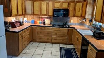 A kitchen with wooden cabinets, a microwave, a stove, and a sink.