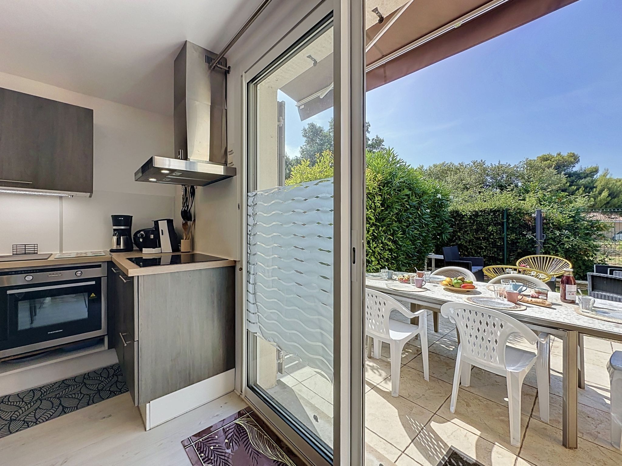 A modern kitchen with a built-in oven and a dining area with a table and chairs.