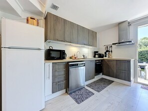 Een moderne keuken met een koelkast, magnetron, vaatwasser en fornuis.