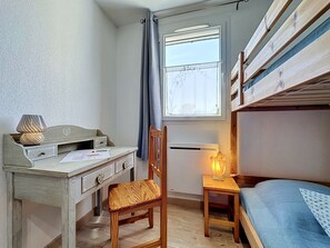 A room with a desk, chair, bunk bed, and a window with curtains. - Mas des Vignes - La Pimprenelle by Interhome (Calvisson)