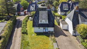 Ett bostadsområde med hus som har sluttande tak, en asfalterad uppfart och en gräsyta.