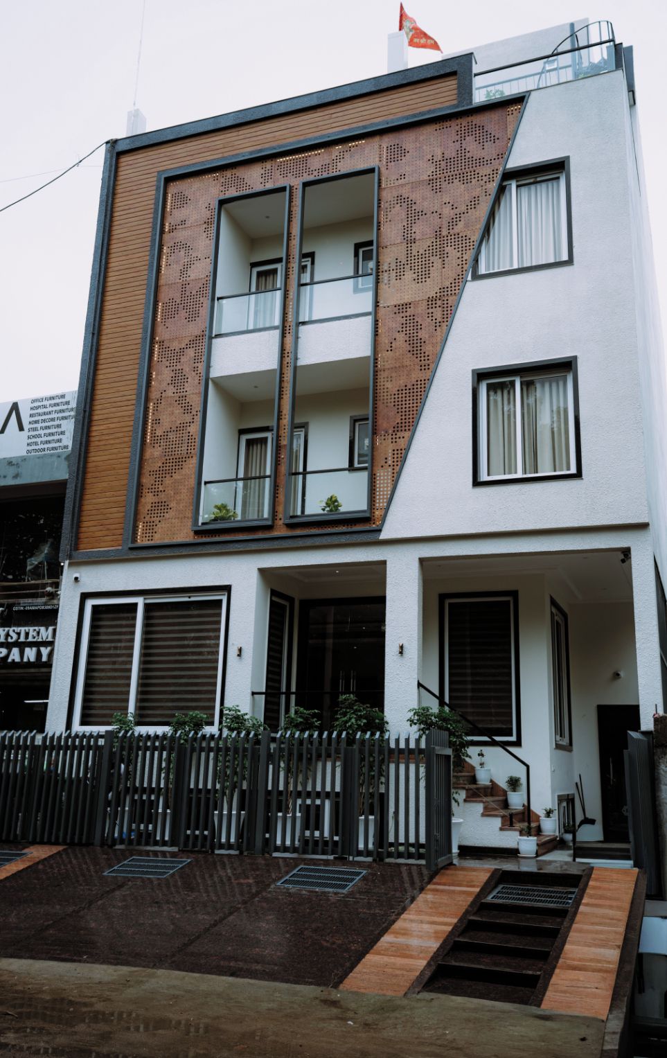 A modern two-story building with a flat roof, large windows, and a wooden facade.