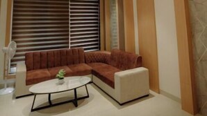 A modern living room with a sectional sofa, a coffee table, and a large chandelier.