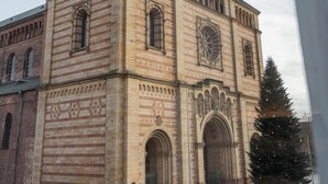 Um edifício histórico com uma torre do relógio imponente e janelas em arco.