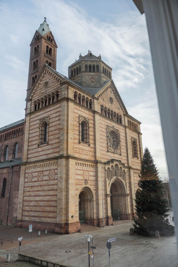 Un edificio storico con una torre dell'orologio ben visibile e ampie finestre ad arco.