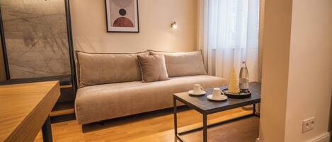 A modern living room with a sofa, a coffee table, and a framed artwork on the wall.
