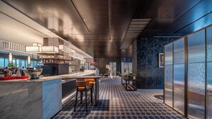 Una zona de bar moderna con una encimera de mármol, taburetes y un cuenco decorativo.