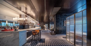 Una zona de bar moderna con una encimera de mármol, taburetes y un cuenco decorativo.