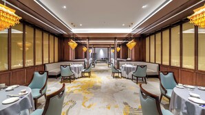 A hotel dining area with round tables, chairs, and chandeliers. - International Hotel LuoYang (Luoyang)