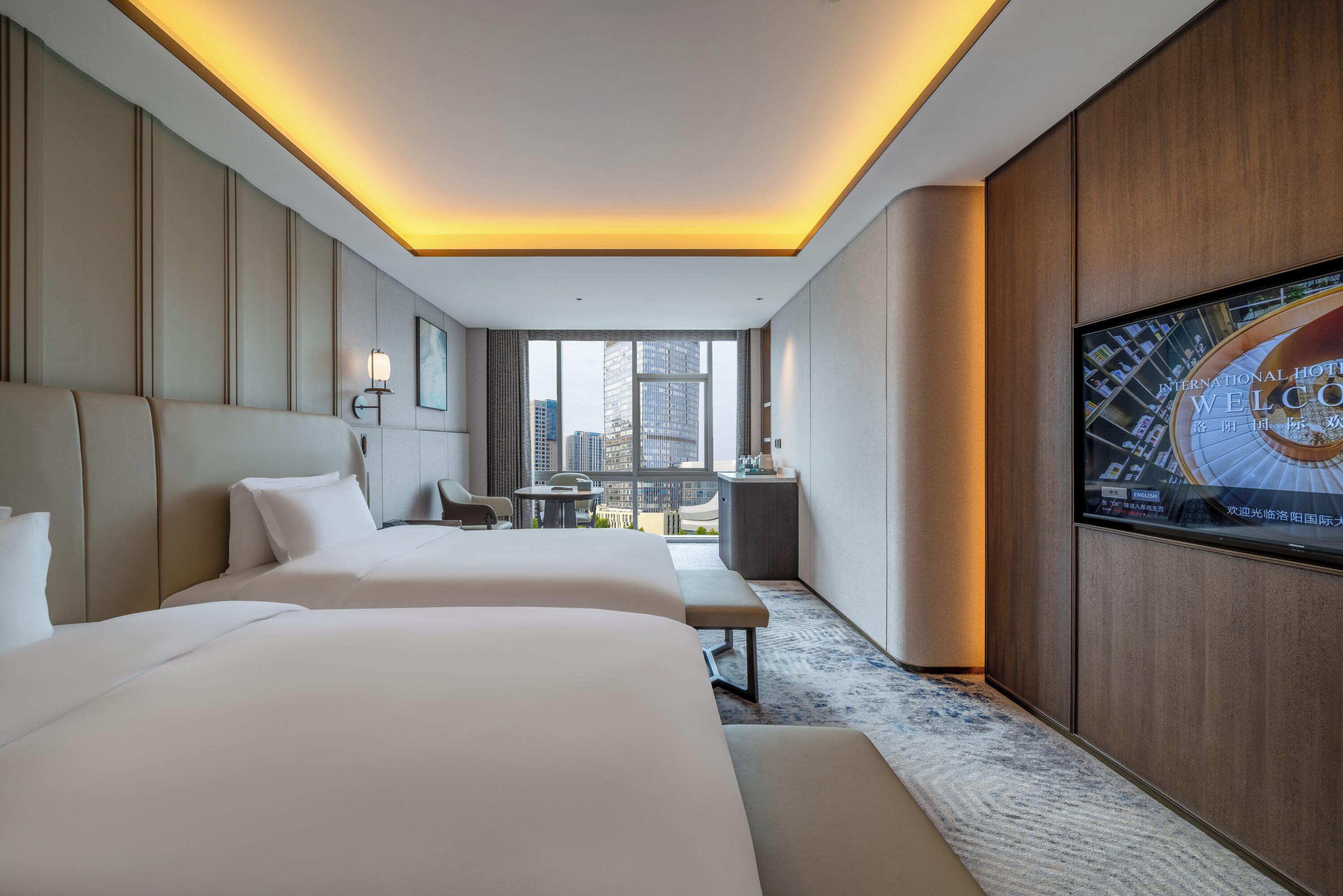 A hotel room with two beds, a TV, and a city view.